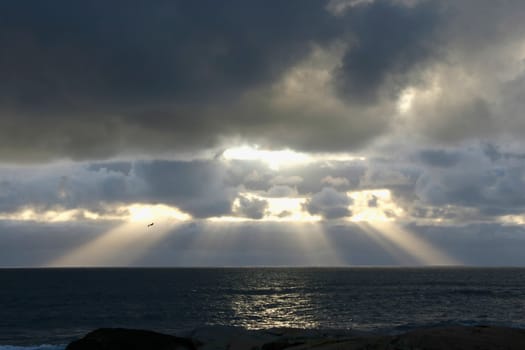 Sun setting over water with brilliant rays of light