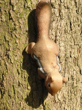 toy squirrel ornament set as if climbing on a tree