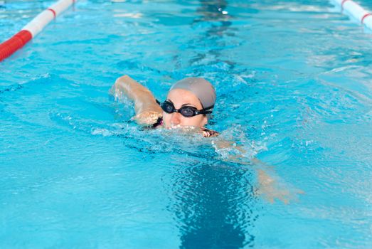 young woman swim on indoor pool close-up. freestyle mode.