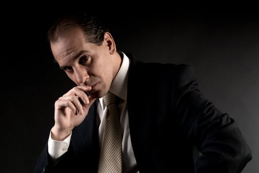 adult businessman serious thinking sitting on dark background