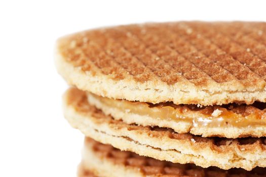 A stack of golden round waffles with caramel isolated over white background.