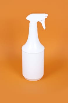 An image of a white plastic spray on orange background