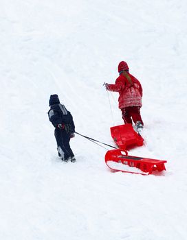 Winter entertainments of children. Driving on sledge.