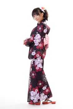 Attractive Japanese woman with traditional clothing looking and smiling against white.