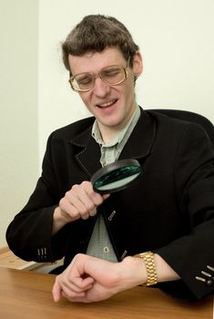 Person examines a watch through a magnifier