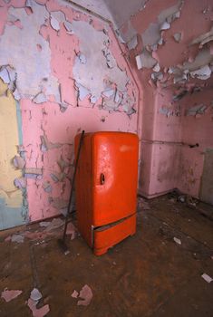 old fridge and a mop in an abandoned building