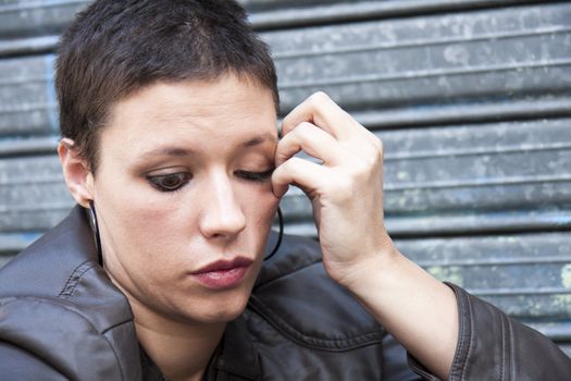 young woman anxious, nervously touching her face with her left hand