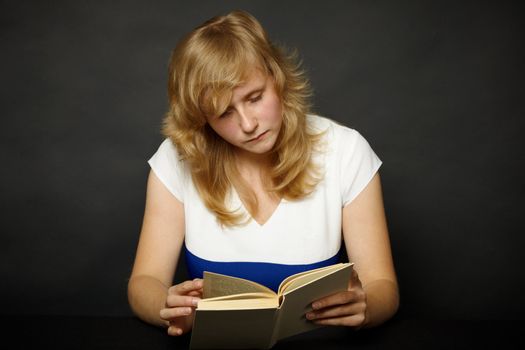 Young woman reading a book at night