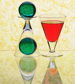 wineglasses and spheres on yellow background