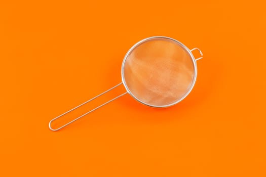 An image of a nice sieve on orange background