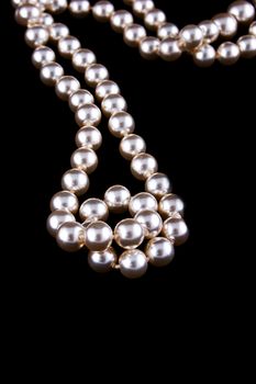 Ivory pearls necklace on black background