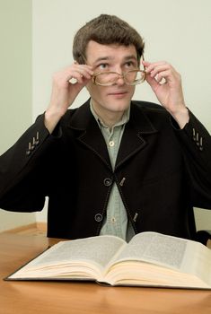 The guy in eyeglasses reads the book