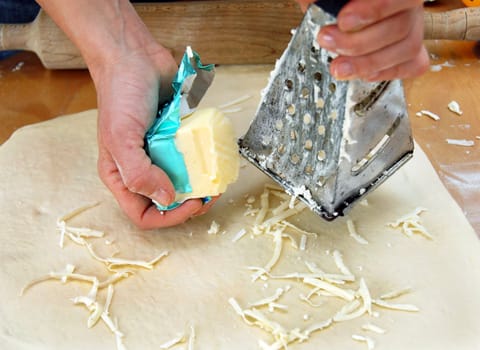 putting grated butter on dough, preparing pastry