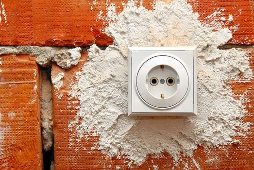 electrical jack installed on red brick wall