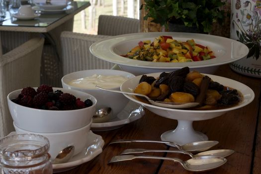 Breakfast buffet of  fruit bowls with silver serving spoons