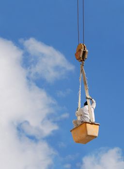 A worker hanging on a steel cable.