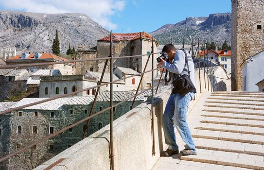 A photographer shooting from the Old Bridge in Mostar
