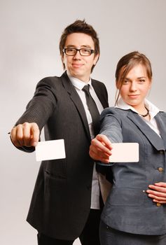 Two business partners holding blank business cards