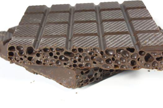 Porous chocolate, photo close up on a white background.