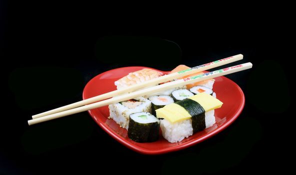 Isolated shot of Sushi on a Black Background with Chopsticks
