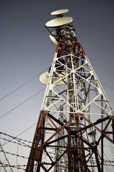 Antenna radio station tower on dark blue sky