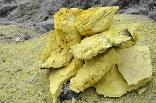 Yellow Sulphur stones beside a volcano landscape