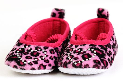 a pair of pink and red baby shoes with a crystal heart on