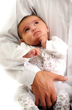 baby looking up at her father while been held in his arms