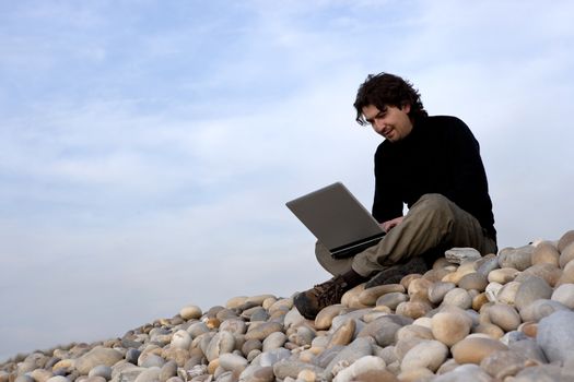 young man with laptop computer in the outdoors - landscape orientation