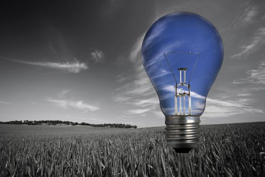 black and white landcape with blue light bulb in the sky - environmental concept