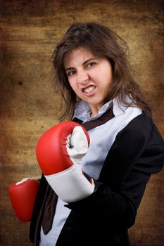 businesswoman with boxing gloves over grunge background