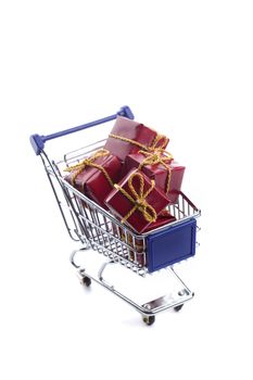 shopping cart full with red christmas present box isolated on white background