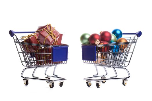 two shopping carts filled with christmas ornaments isolated on white background