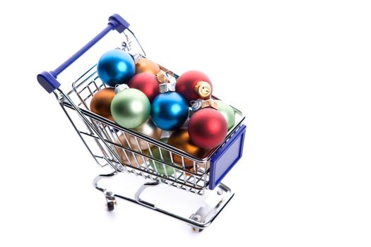 shopping cart full with colorfull christmas balls isolated on white background