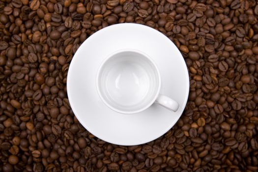 white cup over coffee bean made background. landscape orientation.