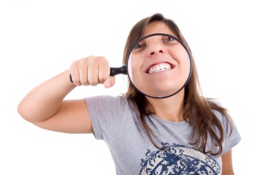 young woman smiling thru magnified glass isolated on white background