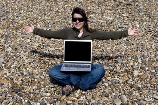 young woman with laptop computer in beach