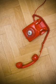 old red telephone laying on the floor