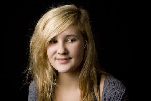Portrait of young beautiful teenage girl on black background
