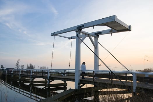 Old wooden lift-bridge in Dutch polderlandscape at sunset