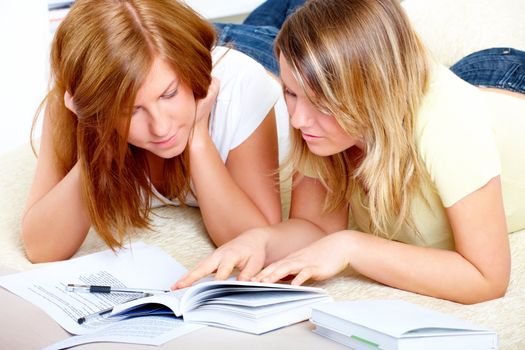 Beautiful girls learning; reading from books