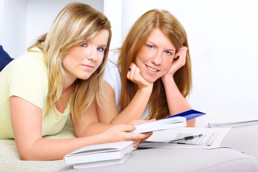 Beautiful girls learning; reading from books