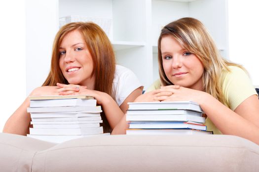 Beautiful girls in home with piles of books