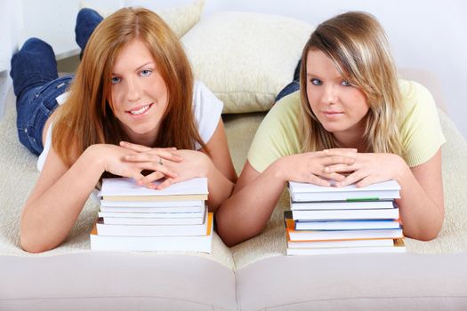 Beautiful girls in home with piles of books