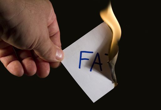 burning piece of paper with word fat written