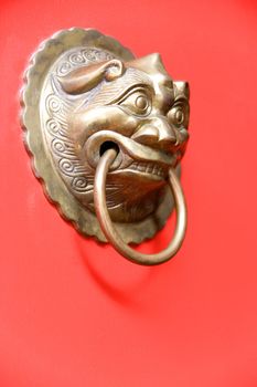 Image of an antique door knob on a bright red door.