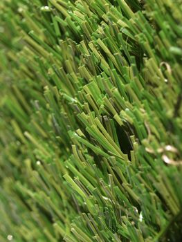 Detail of green grass artificial lawn meadow, useful as a background