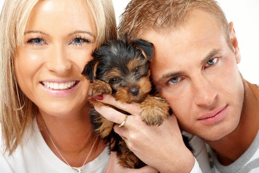 Happy couple with a funny puppy of Yorkshire Terrier