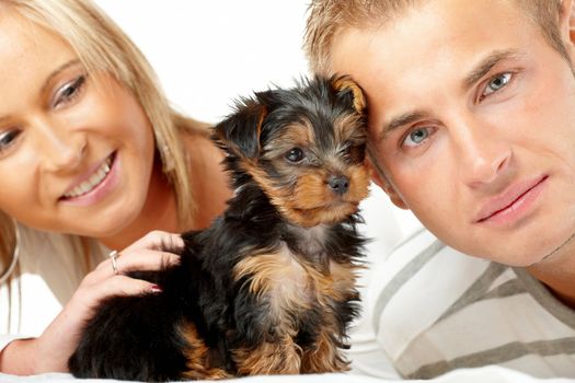 Happy couple with a puppy of Yorkshire Terrier