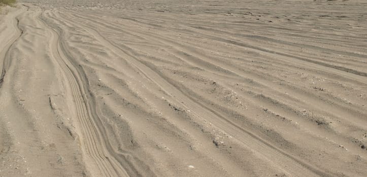 A lonely sandy road with tracks across it